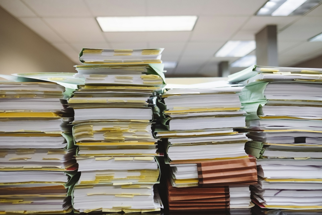 Large stacks of legal paperwork for navigating state regulations for wholesale THCa Flower