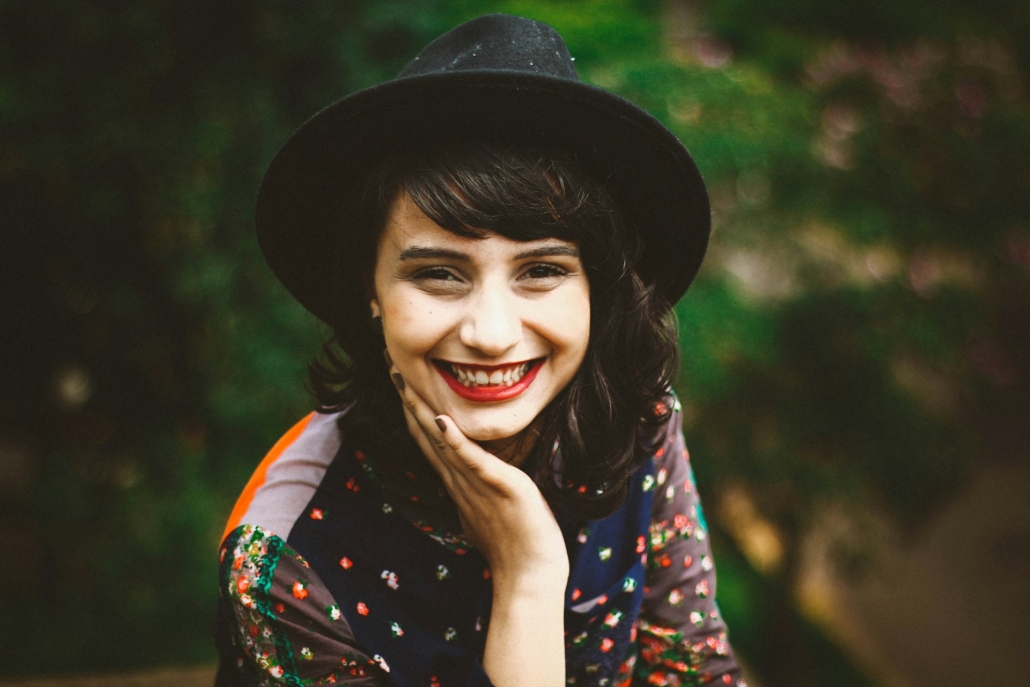 Woman in hat grins at camera. Spectrum of Effects: Exploring the Best Weed Strains 2024 