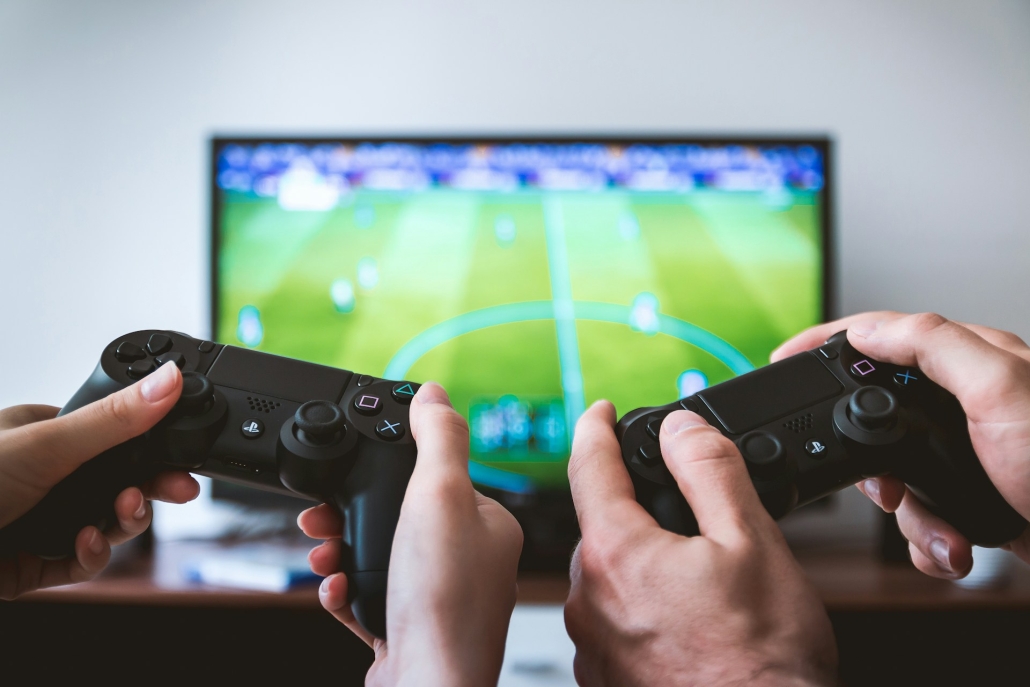 Hands with game controllers, video game in background. Friends use cannabis for recreation, THCa vs THC for psychoactive effects. 